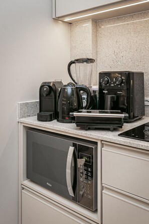 A modern kitchen with a built-in microwave, coffee maker, and toaster. - Do Everything on Foot | Downtown Floripa | #TM101D (Florianópolis)