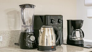Eine Küche mit Mixer, Kaffeemaschine und Geschirrspüler.
