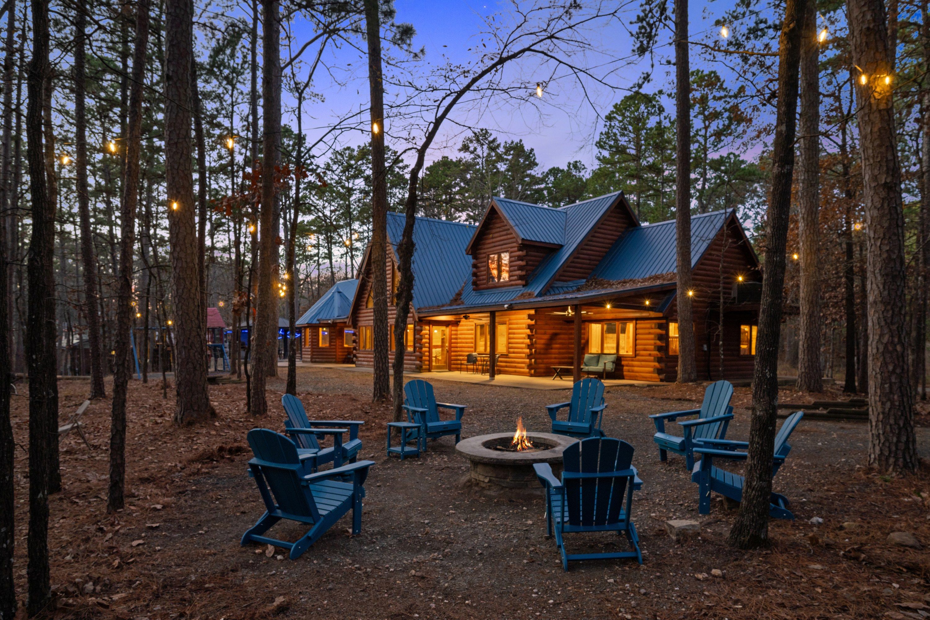 A log cabin with a fire pit and outdoor seating.