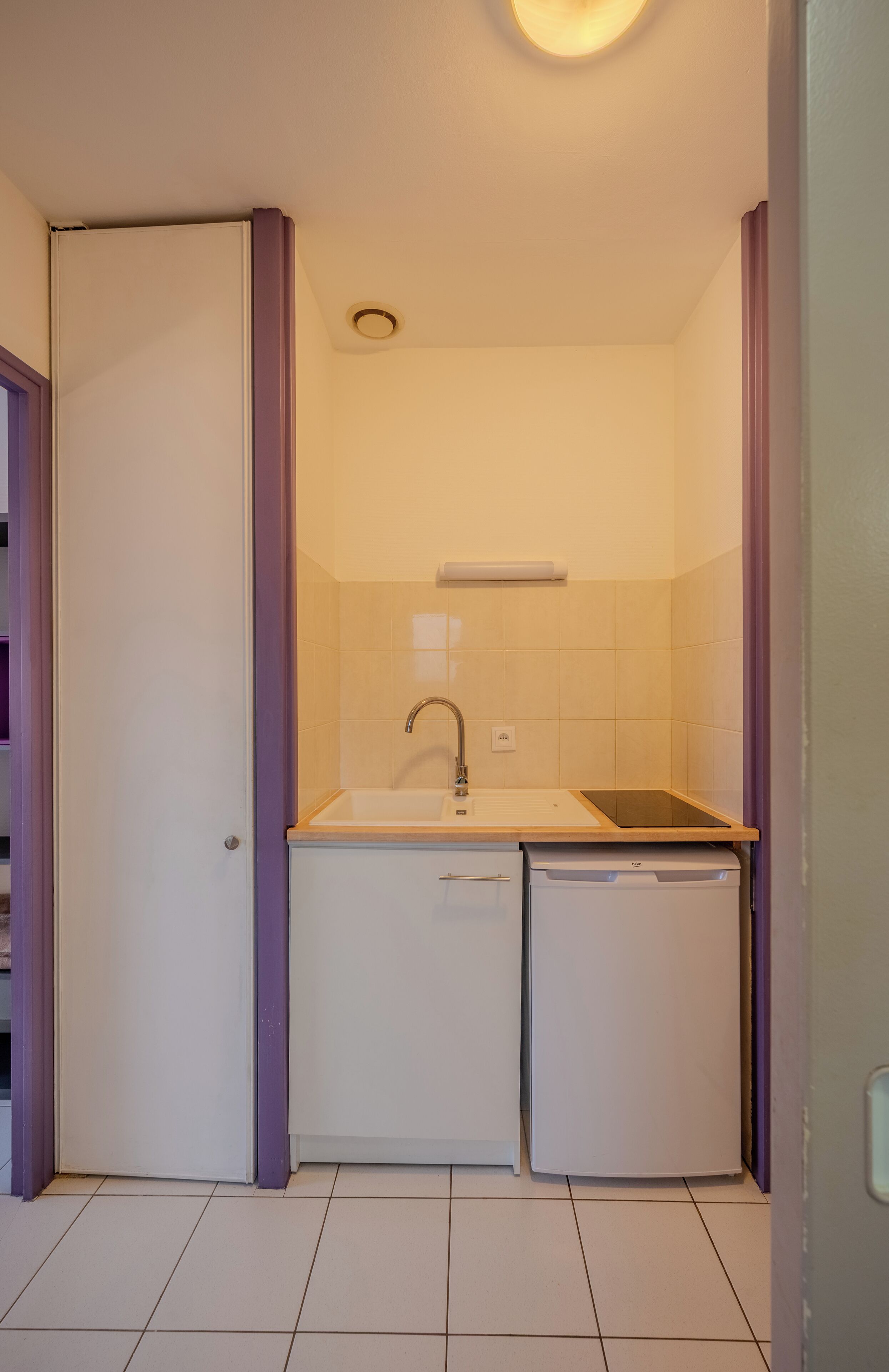 A compact kitchen with a sink, a dishwasher, and a small countertop.
