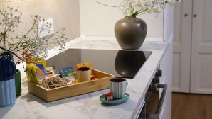 Eine Küchenarbeitsplatte mit einer Speiseplatte, einer Blumenvase und einer Kaffeetasse.