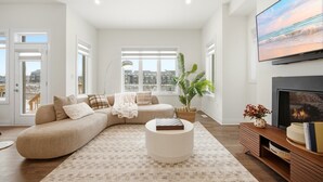 A modern living room with a sectional sofa, a round coffee table, and a fireplace.