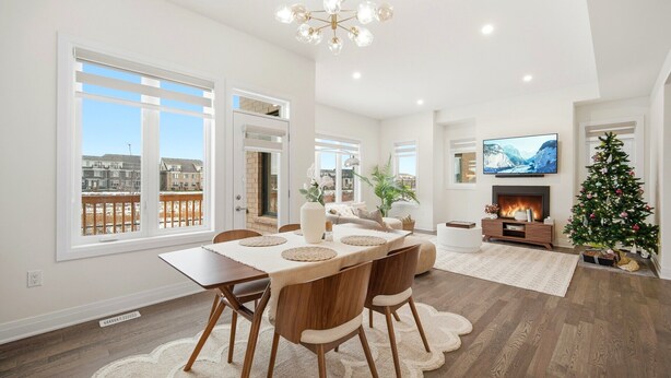 A spacious living room with a dining area, large windows, a fireplace, and a Christmas tree.