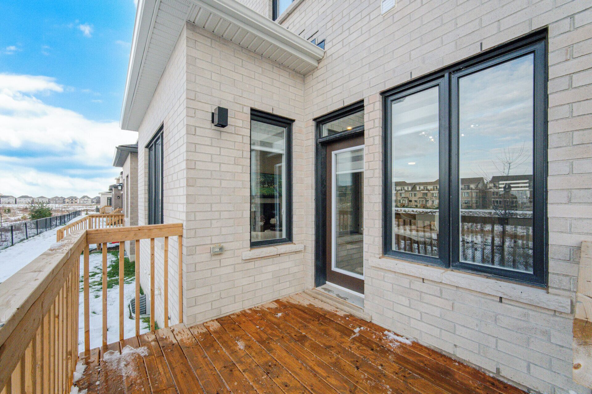 A modern building with large windows and a wooden deck.