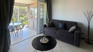Ein modernes Wohnzimmer mit einer Couch, einem Couchtisch und Blick auf eine Terrasse.