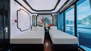 Een moderne kamer met twee bedden, een decoratief schilderij en uitzicht op een wateroppervlak.