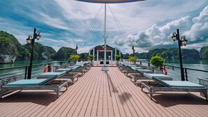 Een terras met lounge stoelen, een centrale paal en een bord waarop 'GARDEN KA' staat.