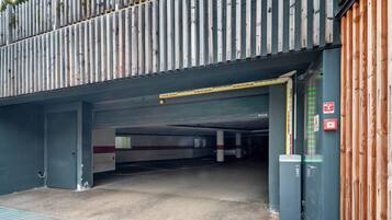 L'ingresso di un parcheggio con una recinzione in legno, un allarme antincendio e un cancello di sicurezza.