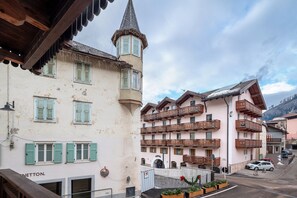Un edificio europeo tradizionale con diversi balconi, una torre e vista sulla strada.