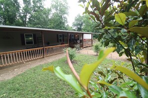 A two-story house with a porch and a small garden. - Adorable 3BR Retreat with Gig-Speed WiFi in Middle Tennessee (Crossville)