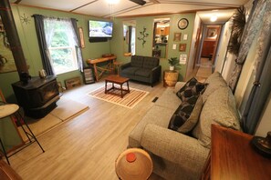A cozy living room with a fireplace, a sofa, a coffee table, and a television. - Adorable 3BR Retreat with Gig-Speed WiFi in Middle Tennessee (Crossville)