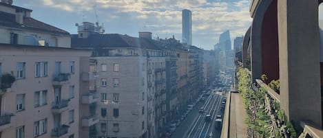A cityscape with multi-story buildings, a busy street, and a clear sky.