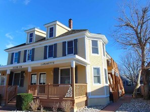 A two-story building with a balcony and a sign that reads "LAGUIETTE." - Modern - Walk to Center of Town Condo (Cape May)