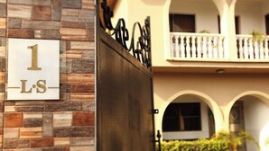 A building entrance with a sign reading "1 LS" and a wrought iron gate. - Lekki Suites (Lekki)