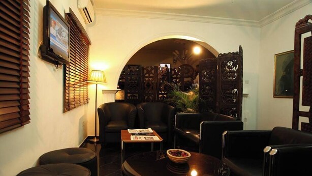 A modern living room with a sofa, armchairs, a coffee table, and a TV. - Lekki Suites (Lekki)