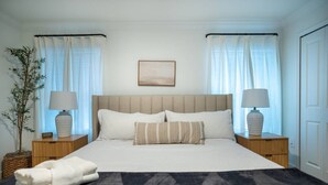 A neatly arranged bedroom with a bed, two bedside tables, a lamp on each, a framed picture on the wall, and a potted plant. - Disney Area 4BR Home w/ Pool & Themed Rooms (Davenport)