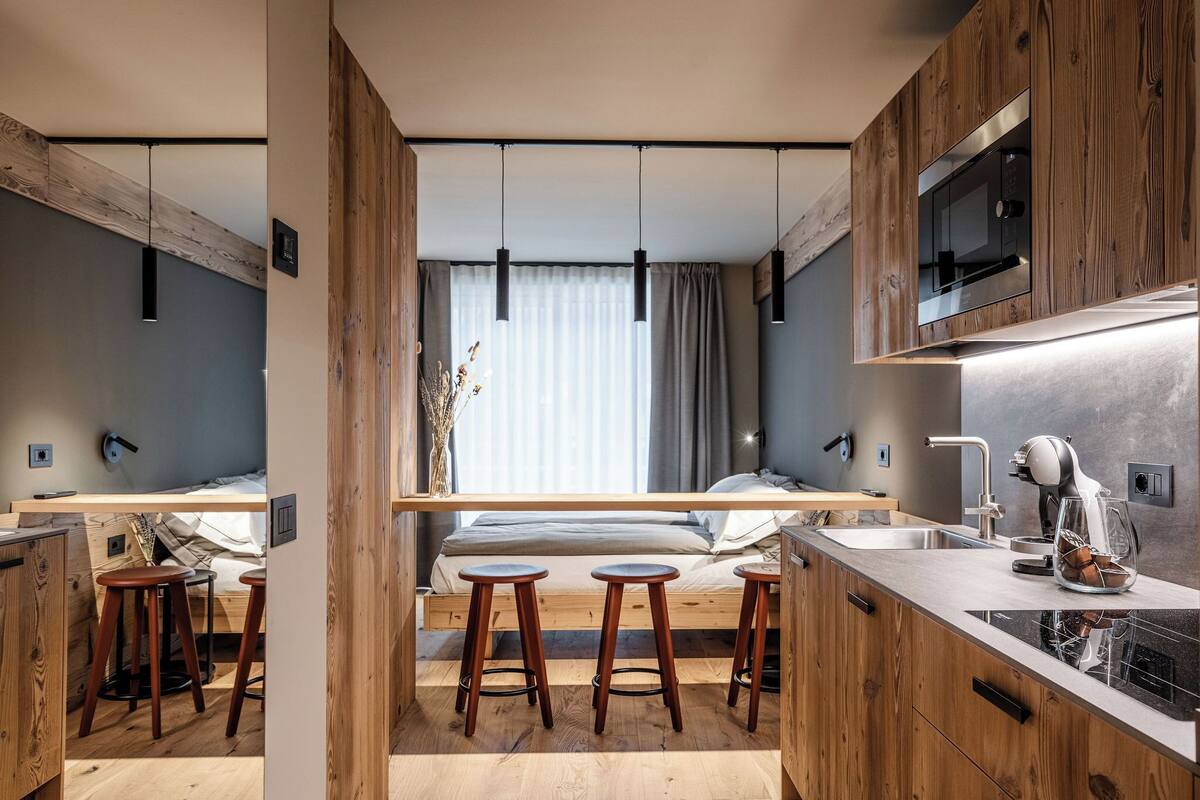 A modern kitchen with wooden accents, a built-in microwave, and a dishwasher.