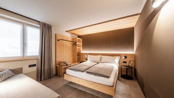 Un dormitorio moderno con una cama de madera, una mesita de noche, un armario y una ventana con cortinas.
