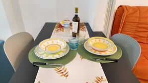 Et spisebord dækket med tallerkener, en flaske, glas og en vandflaske.