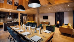 Una cocina amplia con electrodomésticos modernos, un comedor con una mesa grande para seis personas y un ambiente acogedor con chimenea.