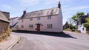 A two-story building with a pitched roof, a front door, and multiple windows. - Vine Cottage (Tewkesbury)