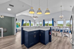 A modern kitchen with dark blue cabinets, a large island, and pendant lighting. - Outer Banks Salvo Family Retreat: Private Pool | Private Hot Tub | Dog Friendly (Salvo)
