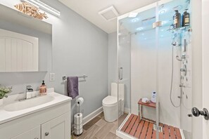 Une salle de bain moderne avec une douche à parois de verre, un lavabo blanc et des toilettes.