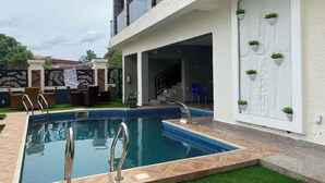 A swimming pool with a metal ladder, surrounded by a herringbone-patterned deck. - Icempire Signature (Lagos)