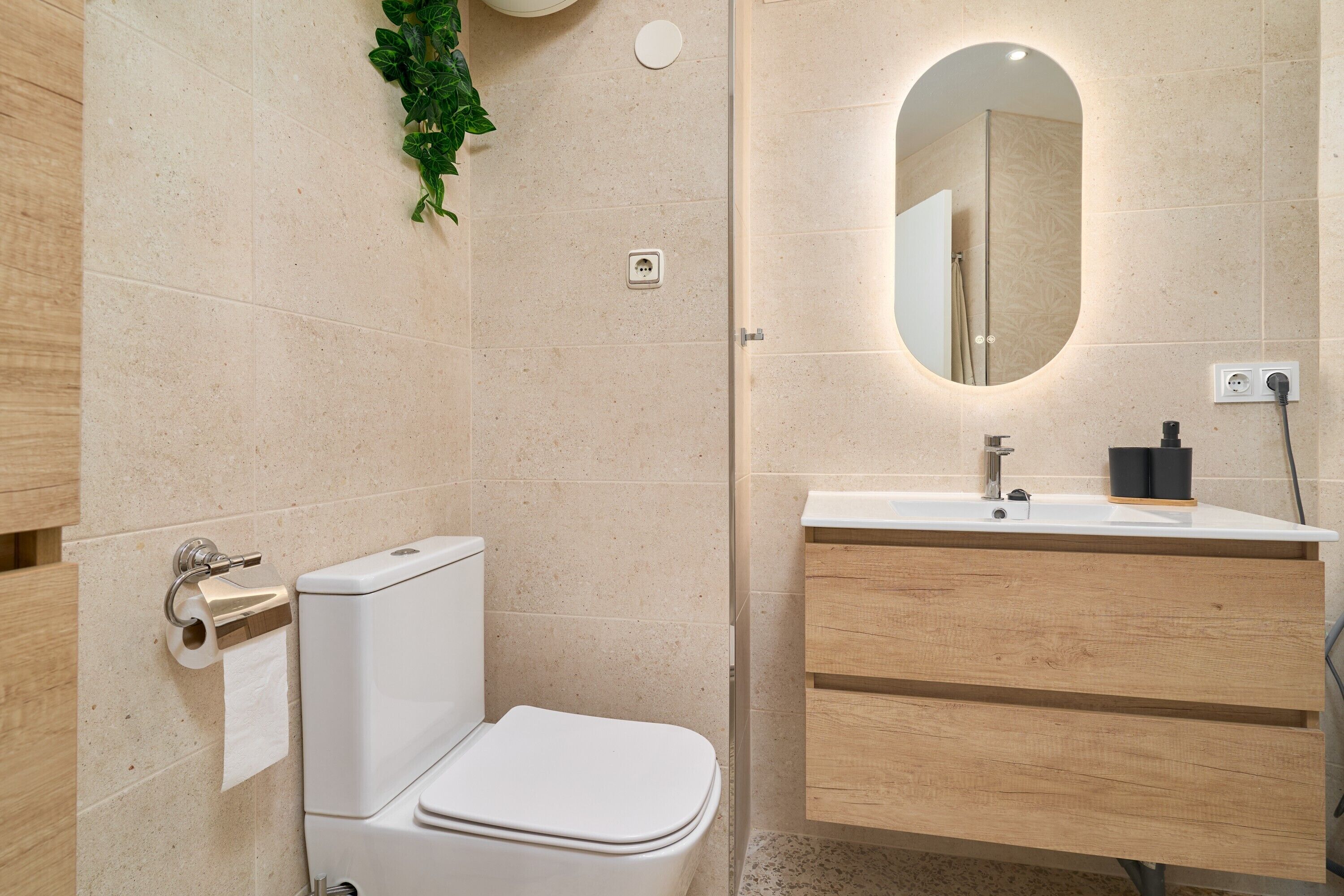 A modern bathroom with a toilet, sink, and mirror.