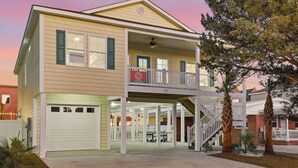 Une maison à deux étages dotée d’un porche avant couvert, d’un garage et d’un escalier menant à l’étage supérieur.