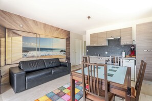 A modern apartment with a living area, a dining table, and a kitchen. - Apartment Terrace over swimming pool (Lavérune)