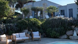 Une villa moderne dotée d’une piscine, d’un espace extérieur aménagé et d’une végétation luxuriante.