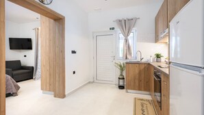 Eine moderne Küche mit Holzschränken, einem Backofen und einem Kühlschrank.