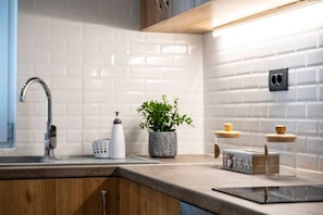 Kjøleskap, ovn, kjøkkenutstyr og spisebord