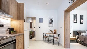 Eine moderne Küche mit Holzschränken, einem eingebauten Backofen und einem Essbereich mit Tisch und Stühlen.