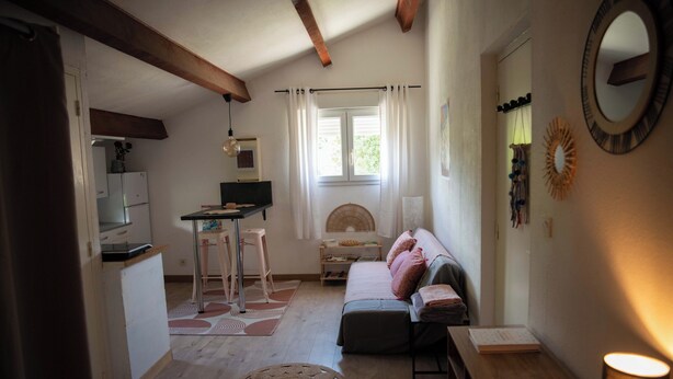 A cozy room with a bed, a desk, a chair, a table, and a mirror.