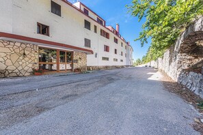 A building with a stone facade, a covered entrance, and a clear sky. - La Casina (Pian De' Valli)