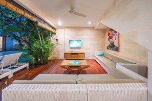 A living room with a TV, sofa, and a wooden coffee table. - Stylish 4BR Canggu Villa • Private Pool & Sundeck • 8 Min to Beach (Badung Regency)