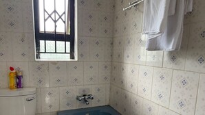 Une salle de bain avec des toilettes, une baignoire bleue et des carreaux à motifs.