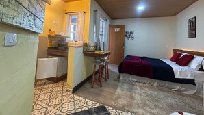 A compact room with a bed, a small kitchenette, and a bathroom. - Skyblue Guesthouse by Concavus (Campos do Jordão)