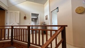Una escalera de madera con barandilla que lleva a un piso superior.