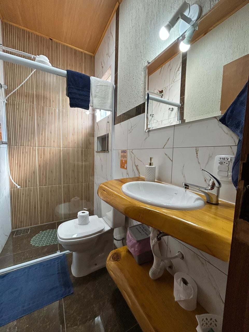 A bathroom with a toilet, sink, and shower area.