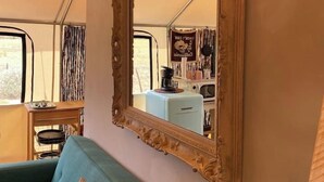 Una habitación con un espejo grande, un sofá y una cuerno decorativa.