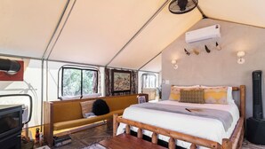 Un interior acogedor con una cama, un sofá, un banco de madera, un televisor y un calentador.