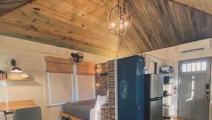 Una cocina compacta con refrigerador, pileta y comedor con mesa y sillas.