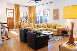 Ein Wohnzimmer mit einer Couch, zwei Sesseln, einem Couchtisch und einer Lampe.