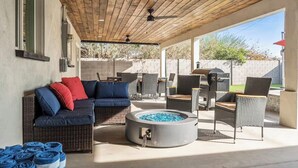 An outdoor patio with a covered seating area, a fire pit, and a grill. - Desert Dream- Retreat with Heated Pool (Scottsdale)