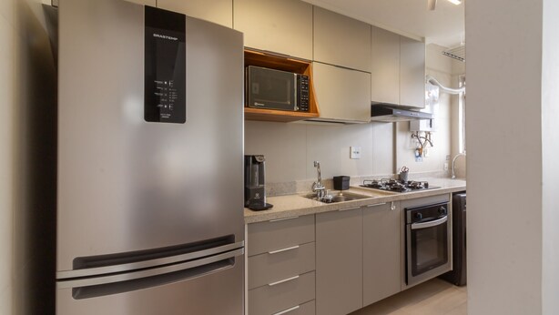 Een moderne keuken met roestvrijstalen apparatuur, een ingebouwde magnetron en een koffiezetapparaat.