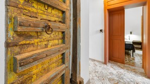 A hallway with a rustic wooden door, a wooden door frame, and a patterned floor.