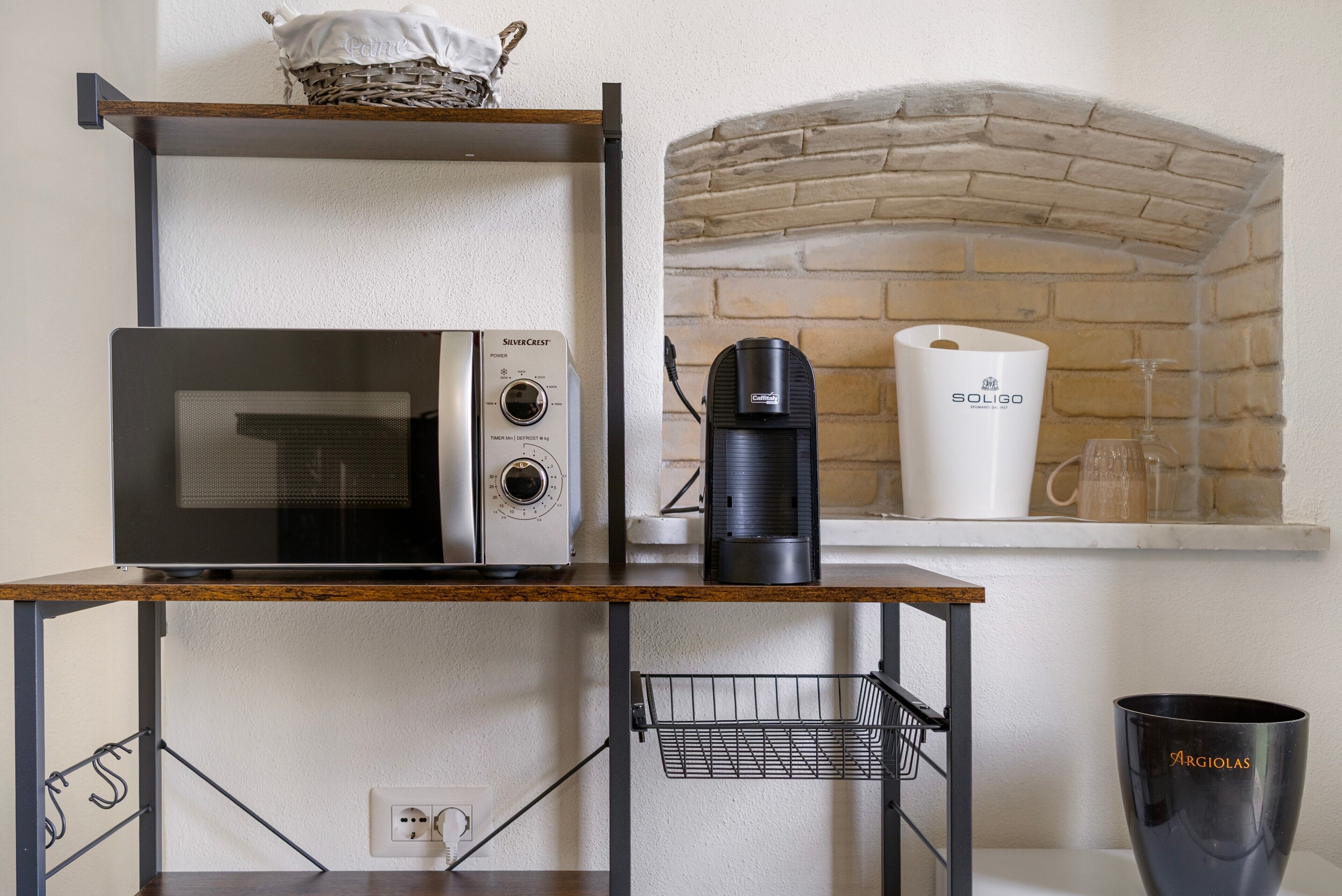 Une cuisine équipée d’un four à micro-ondes, d’une machine à café et d’une cheminée en briques.